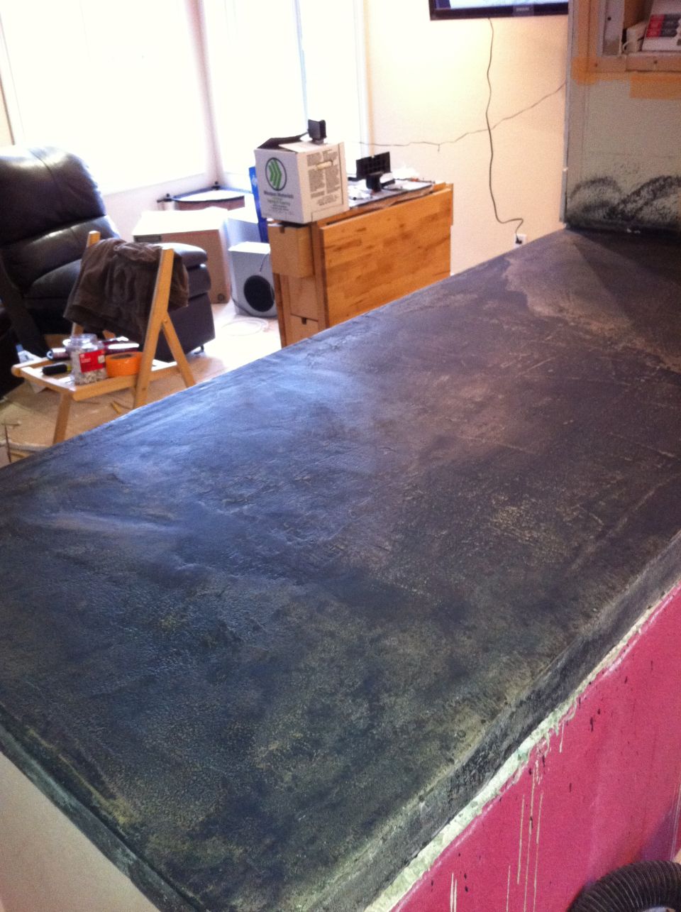 Dark grey countertop with textured finish, red base, and a Supermotors logo at the bottom right