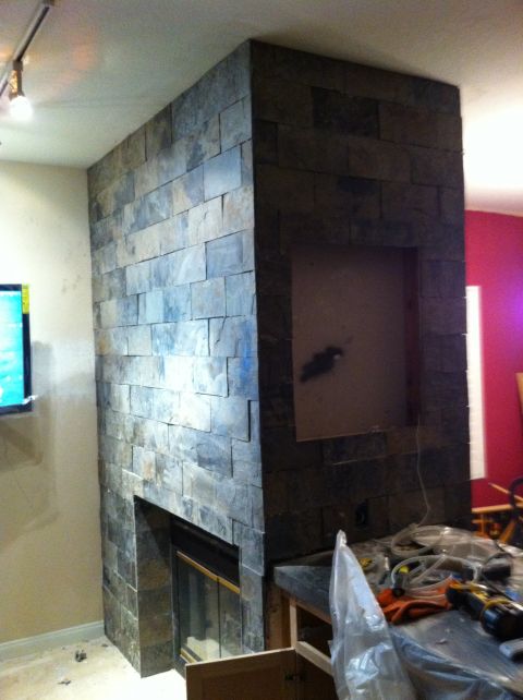 1989 Yugo Cabrio - A stone fireplace is being installed, with tools and materials scattered nearby on a countertop.
