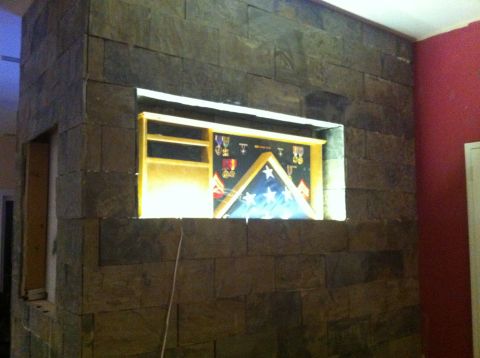 1989 Yugo Cabrio - A display case containing a folded flag and medals is set into a stone wall.
