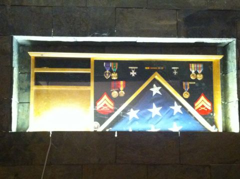 1989 Yugo Cabrio - A shadow box displays a folded flag, military medals, and rank insignia.