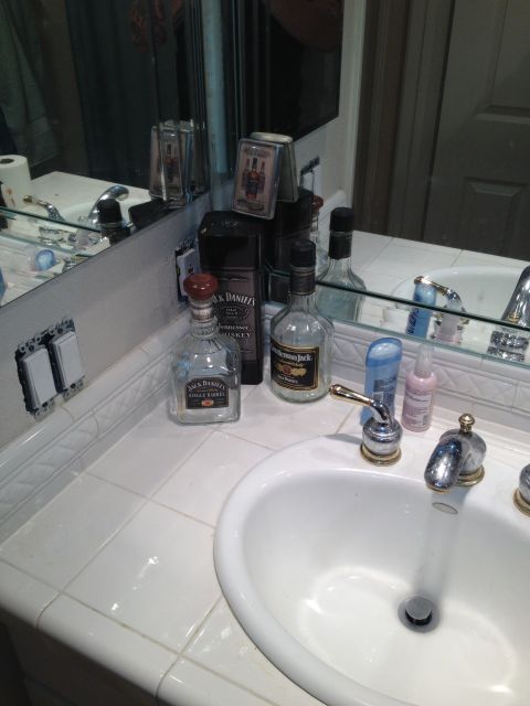 1989 Yugo Cabrio - A bathroom counter displays various bottles and toiletries next to a sink.
