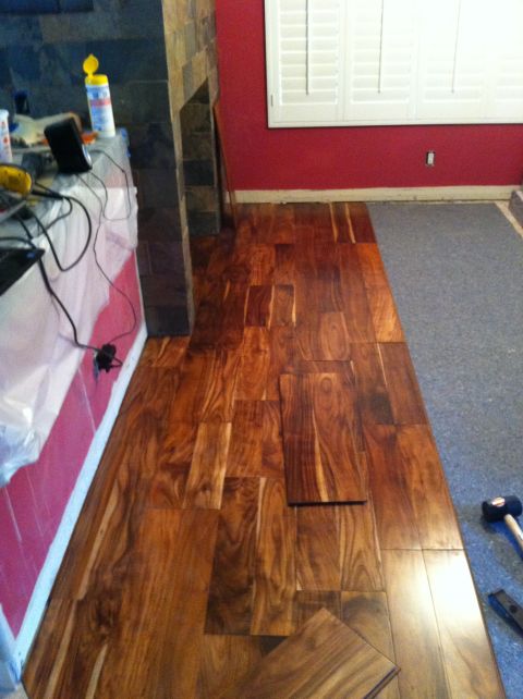 1989 Yugo Cabrio - Installing hardwood floors in a room with a fireplace and red walls.
