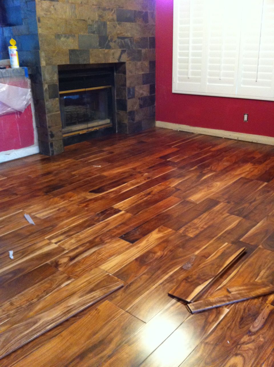 room with fireplace and red walls, new wood floor being installed