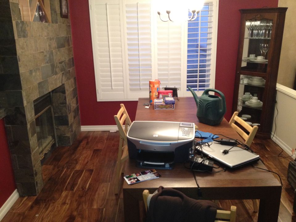 Dining room table with HP printer, laptop, watering can, and boxes