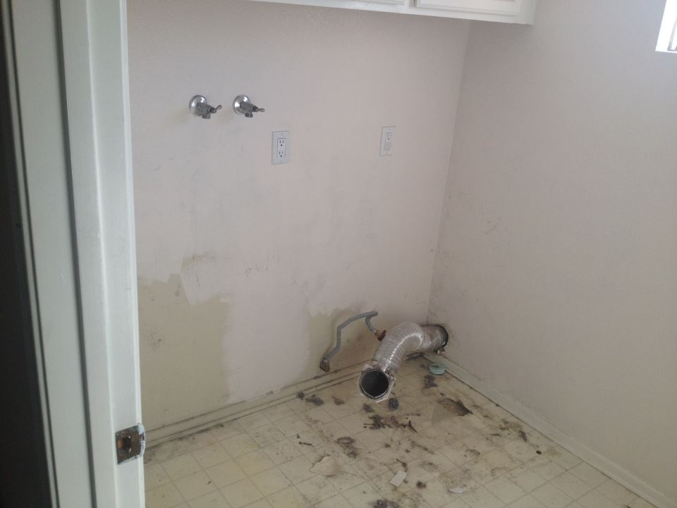 empty room with plumbing hookups and vent pipe on floor