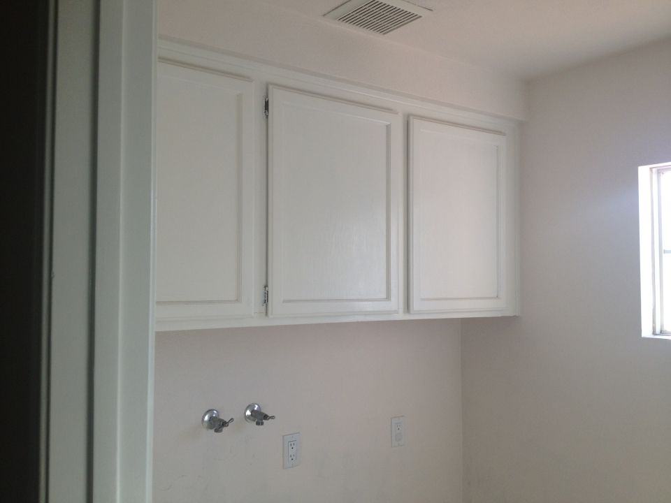 Interior room scene with white cabinets, plumbing fixtures, and a window