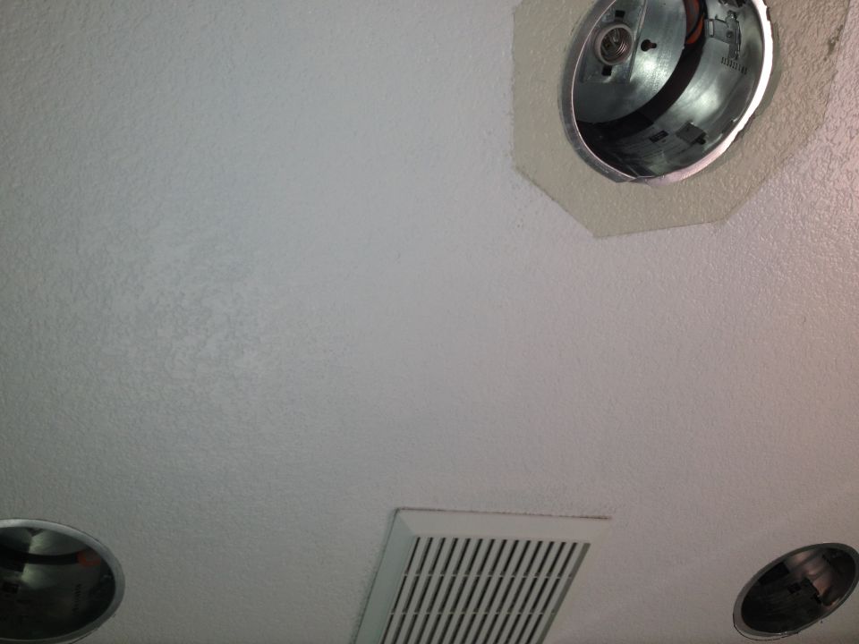 ceiling light fixture and air vent on textured ceiling, with SUPERMOTORS logo in corner
