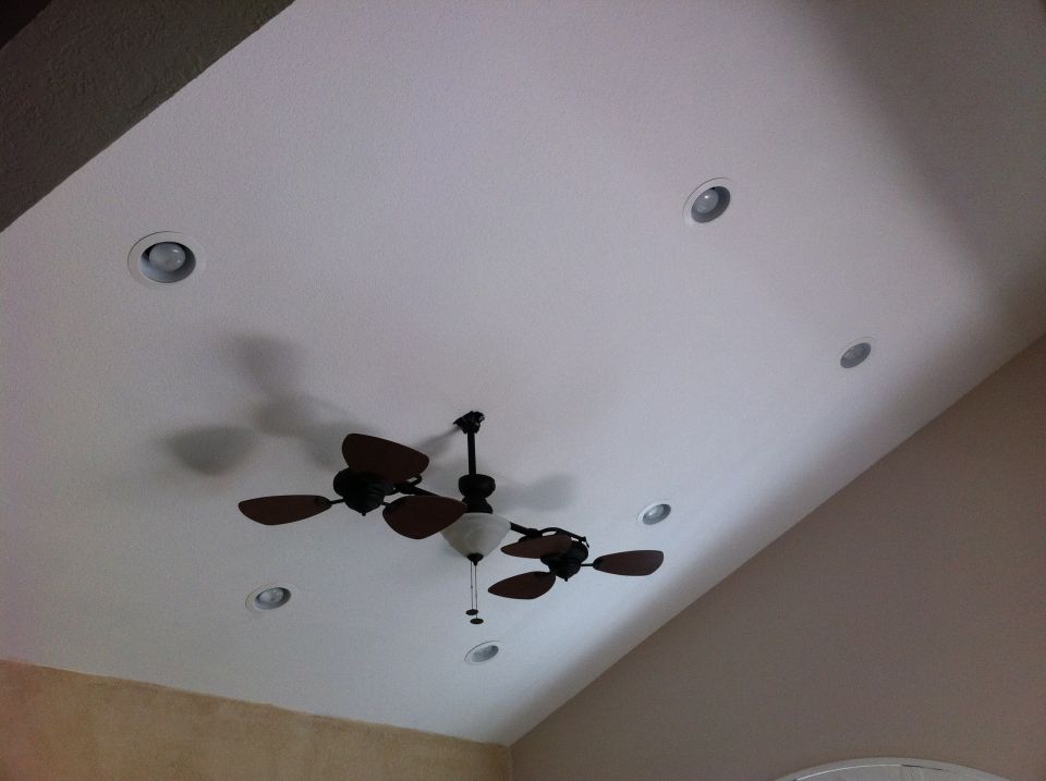 Ceiling with a dark wood ceiling fan and several recessed lights
