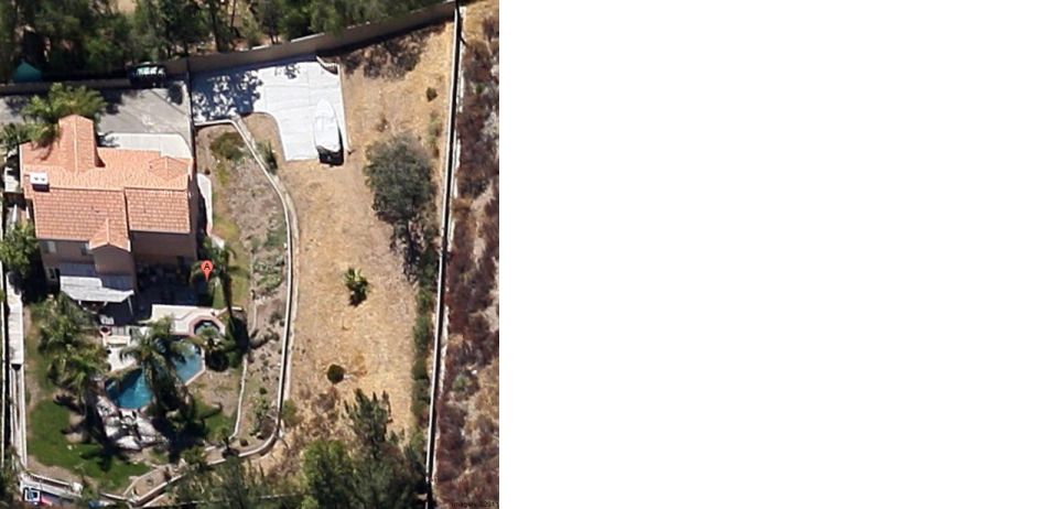Aerial shot of a house with a pool, driveway, and yard. A white object is on the driveway