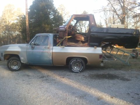 1978 Ford Bronco - A pickup truck carries a disassembled Bronco body, suggesting a project or parts transfer.