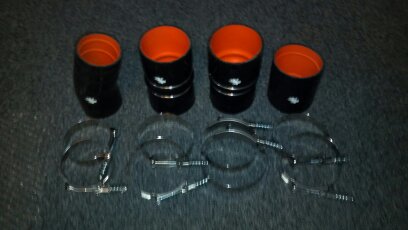 1993 Ford F-150 - A set of four black silicone hoses with orange interiors and four metal hose clamps are laid out on a dark surface.
