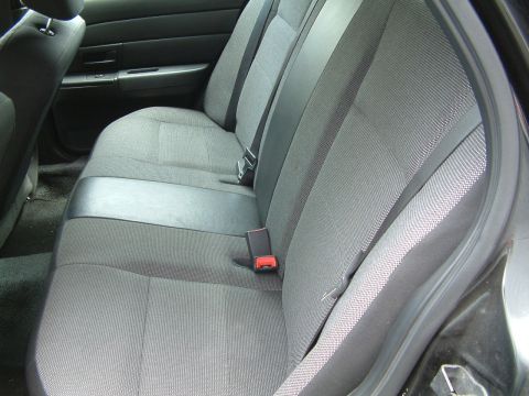 2003 Ford Crown Victoria - Interior view of the rear seating area, showing fabric upholstery and seatbelts.