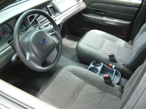 2003 Ford Crown Victoria - The interior of a 2003 Ford Crown Victoria is captured, highlighting the driver's area and passenger seating.