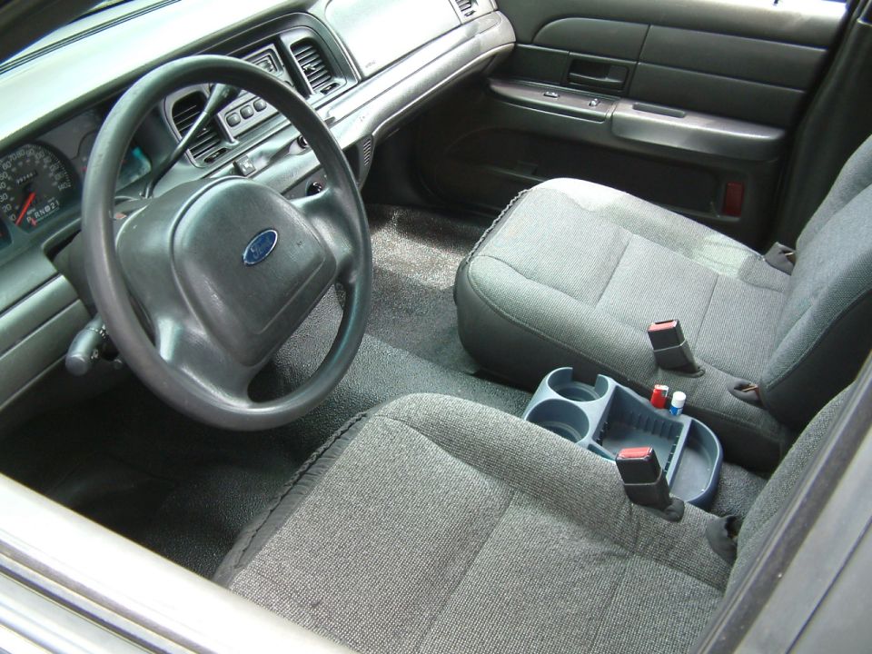 Interior shot of a 2003 Ford Crown Victoria, showing the steering wheel, dashboard, and front seats