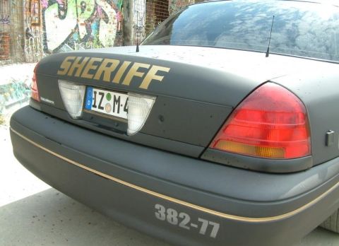 2003 Ford Crown Victoria - Rear view of a 2003 Ford Crown Victoria Police Interceptor marked with "SHERIFF" and unit number 382-77.