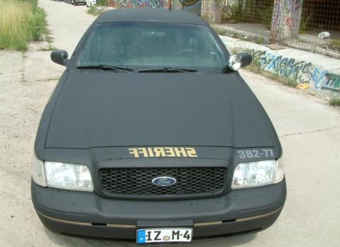 2003 Ford Crown Victoria - This black 2003 Ford Crown Victoria, marked as "SHERIFF", is shown from the front.