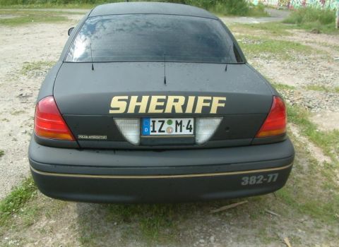 2003 Ford Crown Victoria - This vehicle is marked as 'SHERIFF' and has a German license plate, suggesting it is not a US police car.