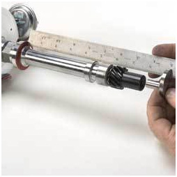 1990 Ford Bronco - A close-up shows a distributor shaft being measured with a metal ruler.