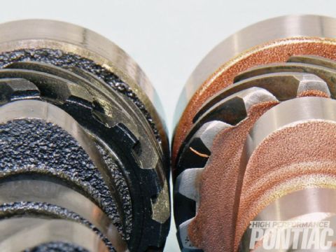 1990 Ford Bronco - Comparison of two distributors, one a black coating and the other a copper coating, highlighting their internal gear mechanisms.