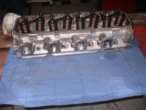 1969 Ford Torino - A disassembled engine cylinder head sits on a blue cloth, showing internal components.