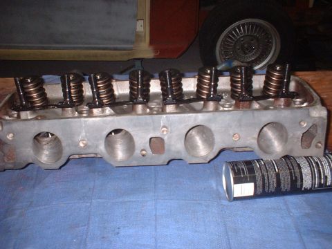 1969 Ford Torino - A close-up view of an engine cylinder head with its internal components, alongside a can of oil.