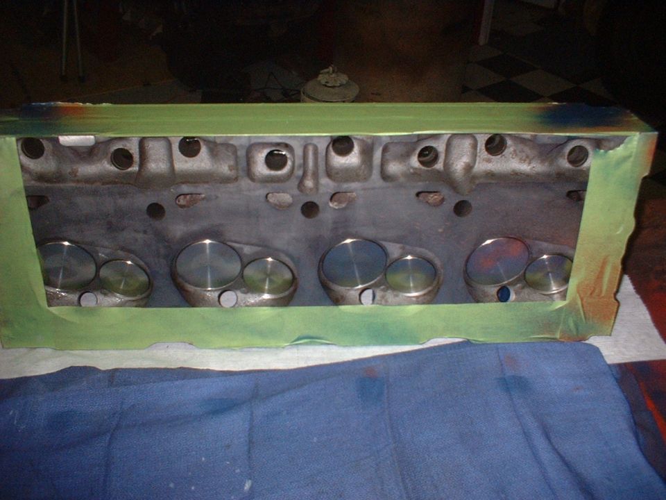 Engine cylinder head with valves, masked with green tape