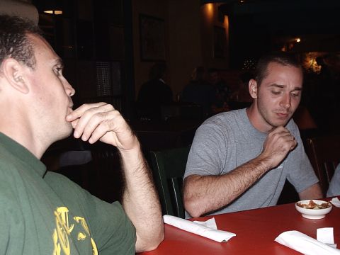 1996 Ford Bronco - Two men are seated at a table indoors, appearing to be in conversation or deep thought.