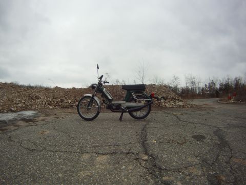 1981 Garelli Rally Sport - A moped sits on a desolate road under an overcast sky.