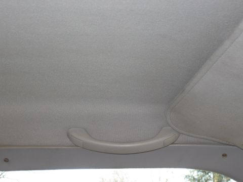 1994 Ford Bronco - A close-up view of a vehicle's interior, focusing on a grab handle attached to the headliner.