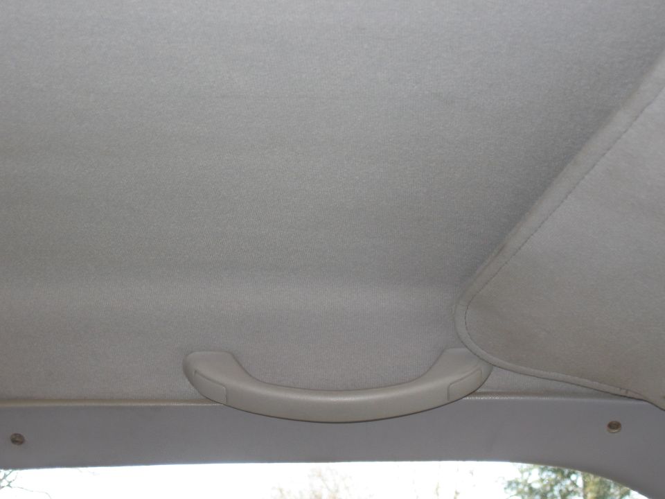 Interior grab handle on the headliner of a vehicle