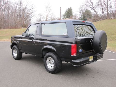 1996 Ford Bronco - This black Ford Bronco is shown from the rear three-quarter view, parked outdoors on a paved surface.