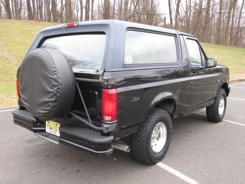 1996 Ford Bronco - Rear view of a black 1996 Ford Bronco, showing the spare tire and license plate.
