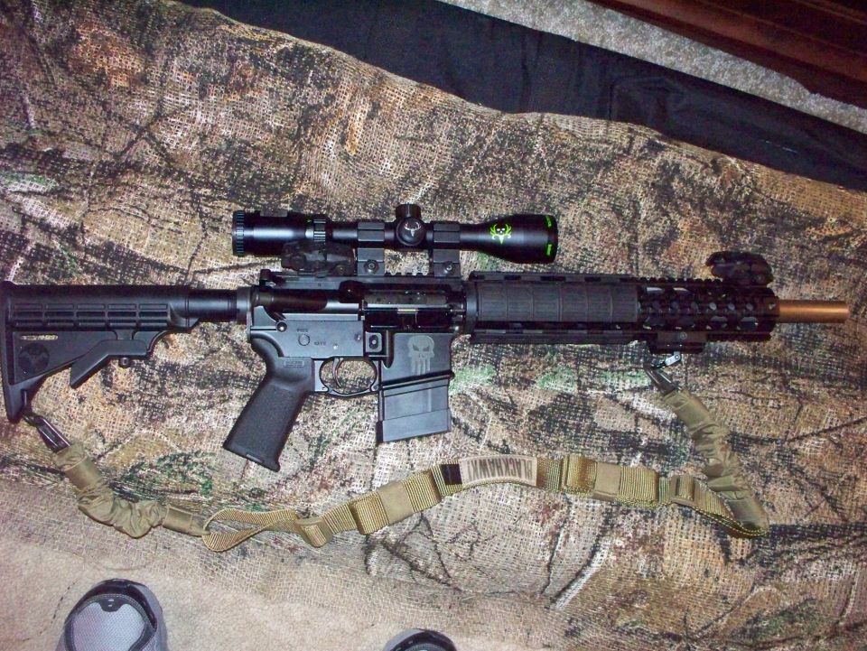 Assault rifle with scope and sling on camouflage background