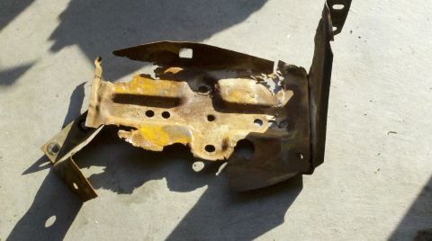 1978 Ford Bronco - This heavily rusted metal bracket appears to be a component from the engine bay of a 1978 Ford Bronco.