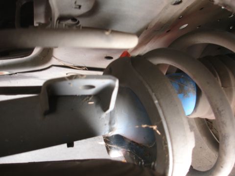 1993 Ford Taurus - Underside view of a vehicle's suspension system, showing a shock absorber and coil spring.