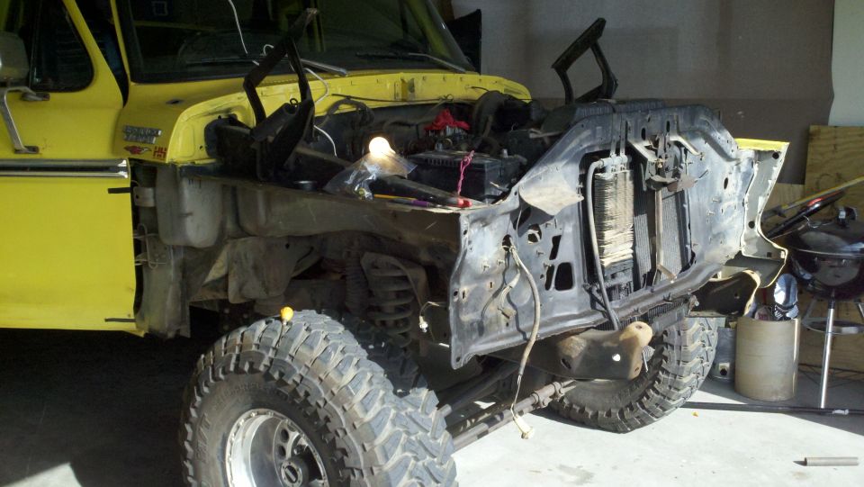 Yellow 1978 Ford Bronco, front clip removed, showing engine bay and suspension components