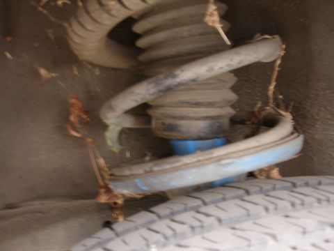 1993 Ford Taurus - A close-up view of a vehicle's suspension system, showing the coil spring and shock absorber.