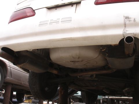 1993 Ford Taurus - Rear view of a white 1993 Ford Taurus SHO sedan, showing its dual exhaust system and taillights.