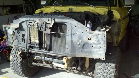 1978 Ford Bronco - Front end of a 1978 Ford Bronco undergoing motor rebuild, radiator and surrounding parts are exposed.