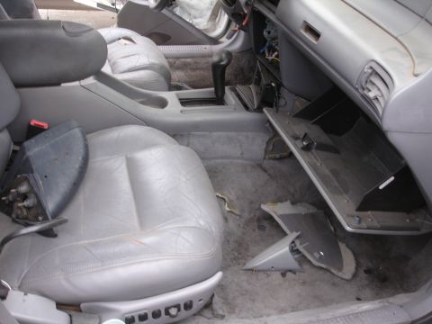1993 Ford Taurus - The interior of a 1993 Ford Taurus shows signs of disrepair, with detached trim pieces and an open glove compartment.