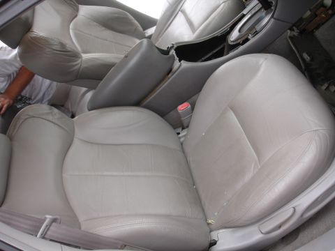 1993 Ford Taurus - Interior view of a car's front seats and center console, showing light gray leather upholstery.
