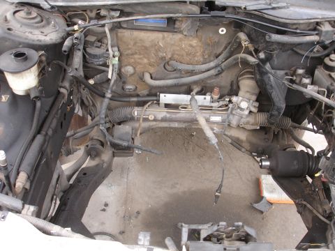 1993 Ford Taurus - The engine bay is partially disassembled, showing various hoses and the steering rack.