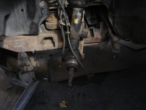 1993 Ford Taurus - Close-up view of a vehicle's front suspension and driveshaft assembly.