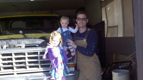 1978 Ford Bronco - A family poses in front of a truck that appears to be undergoing some work.