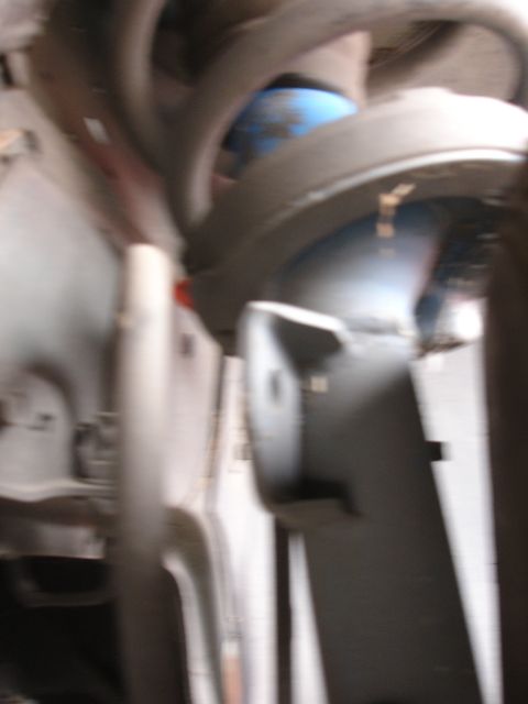 1993 Ford Taurus - Detail of a vehicle's suspension system, showing a shock absorber and spring assembly.