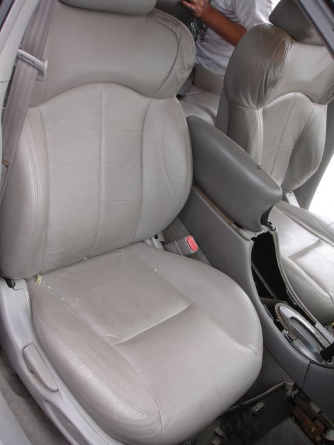 1993 Ford Taurus - The interior of a car features light gray leather seats and a center console, with a person visible in the background.