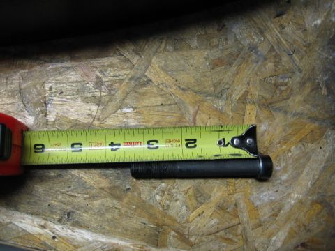 1995 Ford Bronco - A bolt is measured with a tape measure, indicating its length.