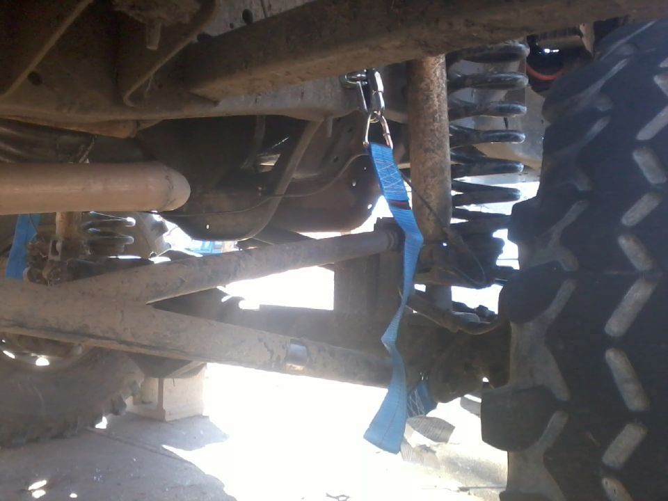 Undercarriage view showing suspension components and a blue strap attached to the frame