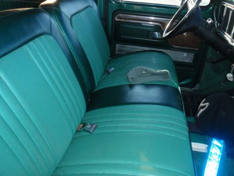 1978 Ford Bronco - Interior view of a green vehicle with two-tone seats and a skull charm on the steering column.