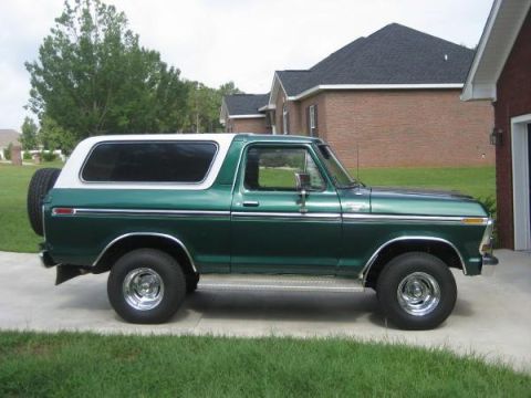 1978 Ford Bronco - This classic green Ford Bronco is parked in front of a brick house on a sunny day.